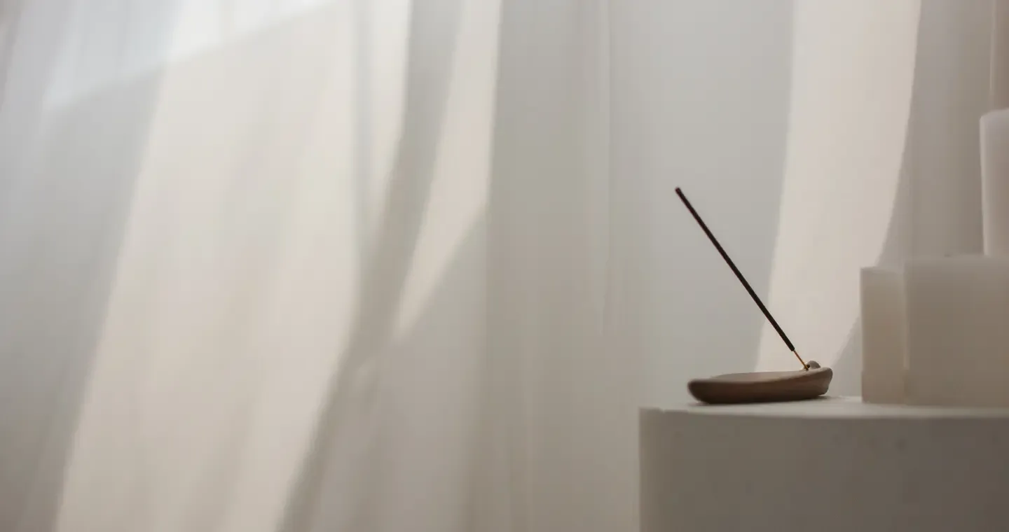 Hypnosis for stress and anxiety in Dutchess County NY, incense stick and candles in soft light through a sheer curtain