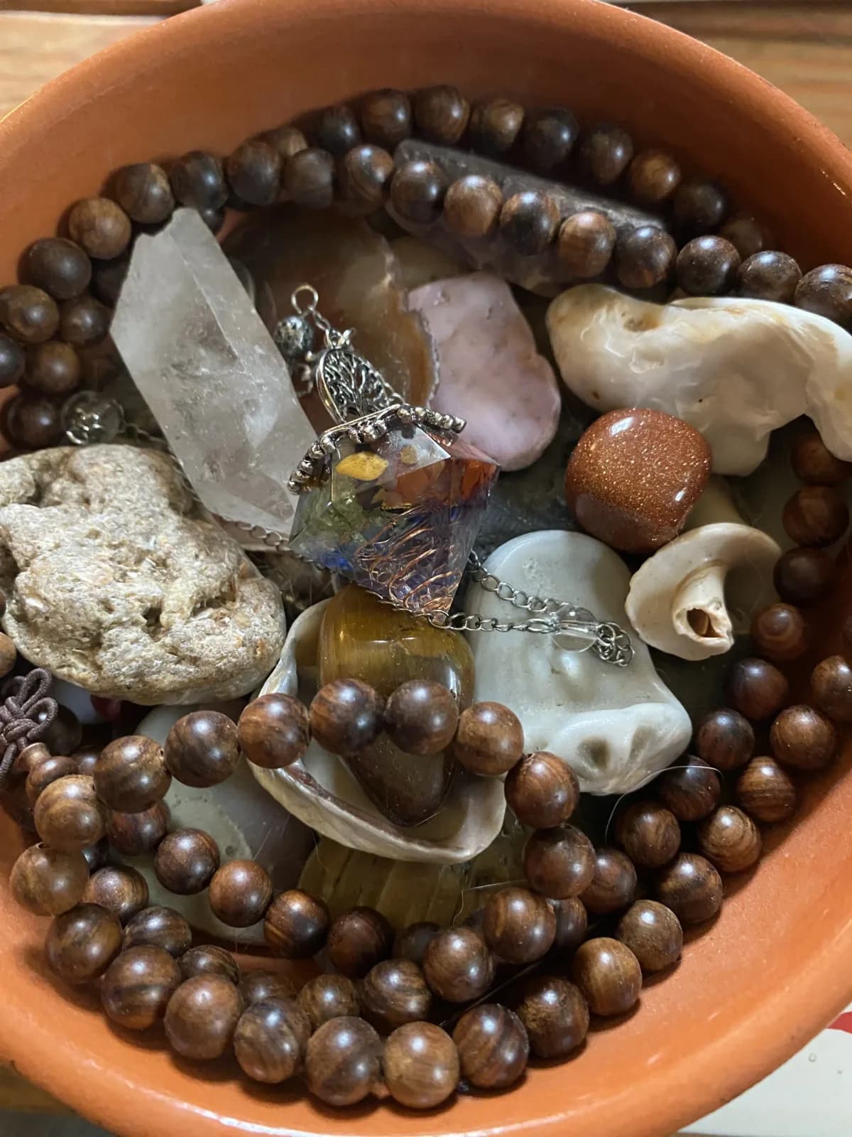 A clay bowl of stones, shells, crystals and wooden beads in the Hope Still Hypnosis studio